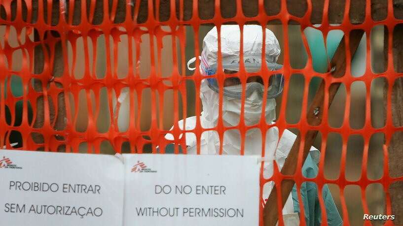 A health worker in protective clothing peers out from behind barriers marking the isolation ward whe.. مساحة نت | السعودية تدعو مواطنيها إلى الامتناع عن السفر لهاتين الدولتين.. بسبب فيروس ماربورغ